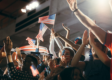 Immigrants holding flags, representing job offers and employer-sponsored visa requirements.
