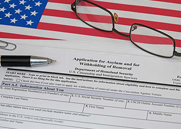 US asylum application form with a pen, outlining the one-year filing deadline rule.