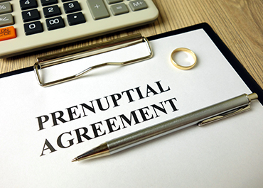 Prenuptial Agreement document with pen and wedding ring for family law planning.